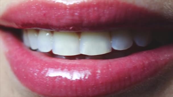 Женский открытый улыбающийся рот с сексуальным розовым блеском для губ и языком. Крупный план — стоковое видео