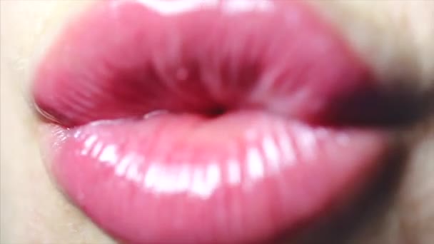 Roze glanzend vrouwelijke lippen. Witte tanden, tong. Lucht kus closeup — Stockvideo