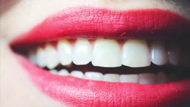 Hermosos labios de mujer con lápiz labial rojo, chica lamiéndose los dientes. Primer plano. — Vídeos de Stock