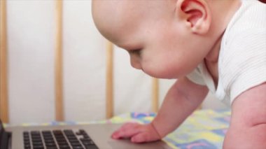 Yavaş hareket görünümü küçük 6 ay bebek çocuk ve laptop klavye üzerinde eller