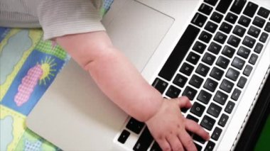 Yavaş hareket görünümü küçük 6 ay bebek çocuk ve laptop klavye üzerinde eller
