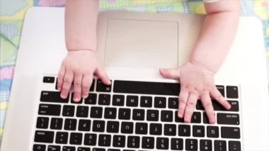 Laptop klavye ve çocuğun elleri. Yatakta dizüstü bilgisayar ile oynayan çocuğun portre
