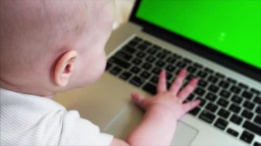 6 ay eski erkek bebek yatakta laptop önünde chroma anahtar perde ile yatıyor