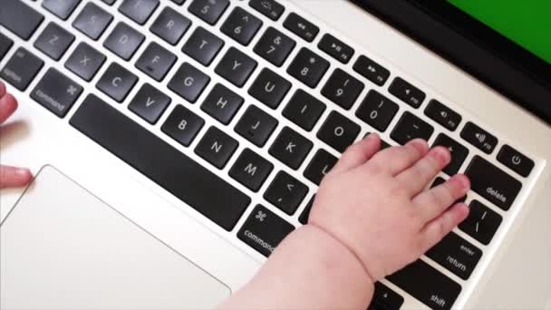 Visão de câmera lenta do teclado do laptop e pequenas mãos de menino de 6 meses nele — Vídeo de Stock