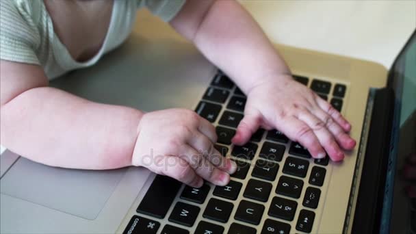 Retrato em câmera lenta de menino de 6 meses brincando com laptop em sua cama — Vídeo de Stock