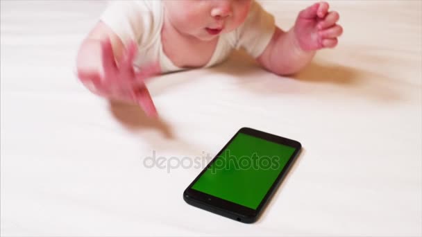 Vista de cerca de adorable niño de 6 meses jugando con el teléfono inteligente — Vídeo de stock