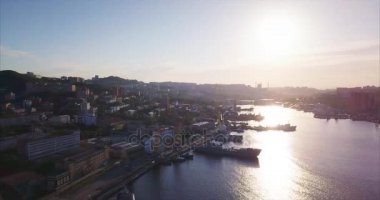 Altın Boynuz Limanı 'nın üzerinde geriye doğru uçan Japon Denizi' nin korunaklı boynuz şeklindeki körfezi. Buraya ve Vladivostok şehrine demirlenmiş farklı gemilerin havadan görüntüsü. Güzel gün doğumu. Rusya