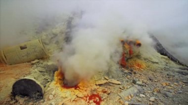 Doğu Java, Endonezya 'daki Ijen volkanında yanan sülfür kaynaklı zehirli kokulu sarı dumanların yakın görüntüsü 