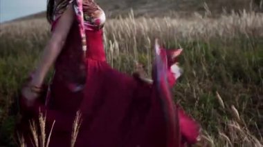 Güzel elbiseli çingene kadının mavi gökyüzü arka planında gülücüklerle dans edişi görüntüsü