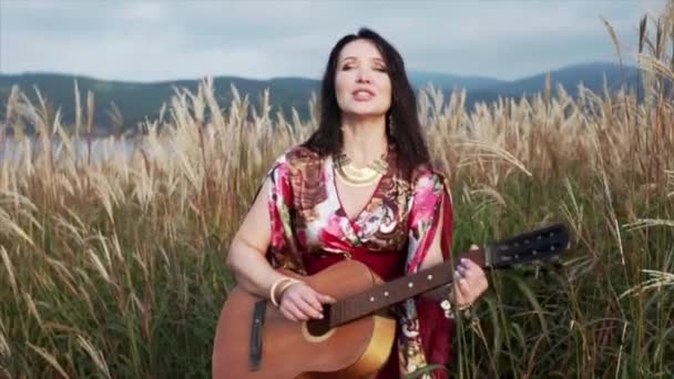 Beautiful Gipsy Woman Long Dress Playing Guitar Singing High Grass — Stock Video