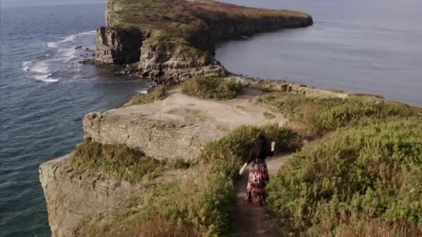 Панорамный Вид Цыганку Красивом Платье Идущую Высокой Скале Над Океаном — стоковое видео