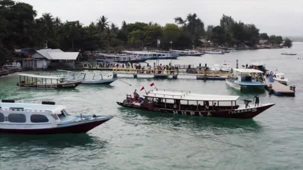 2019年7月4日インドネシア 熱帯の島を背景に 観光客と一緒に桟橋から出航するボートの空中ビュー — ストック動画
