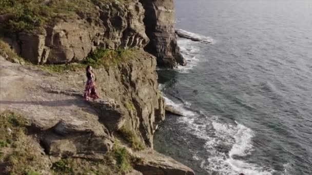 Okyanusun Yukarısındaki Yüksek Kayalıklarda Duran Güzel Elbiseli Çingene Kadının Hava — Stok video