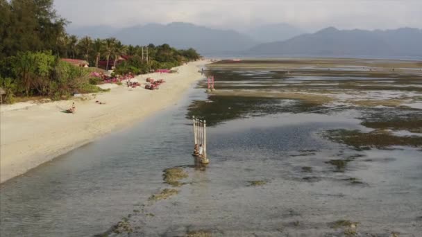 印度尼西亚吉里岛的沙滩海岸线 有旅游胜地 在低潮和绿色丛林中靠近海洋的绿色丛林 — 图库视频影像