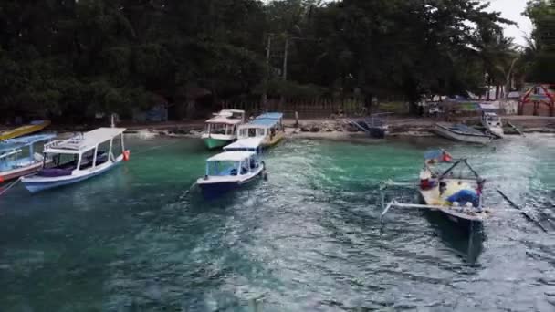 インドネシアのジリ島に係留された透明ブルーの海の水の上のモーターボートの空中ビュー — ストック動画