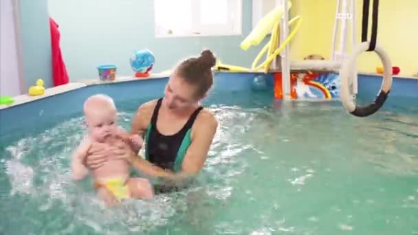 Erkek Çocuk Yüzüyor Yüzme Havuzunda Eğitmenle Fiziksel Egzersiz Yapıyor — Stok video