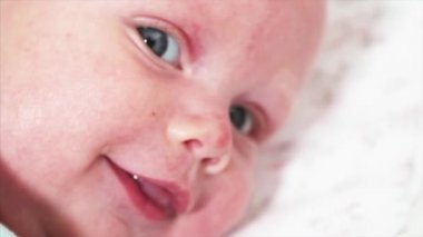 İki aylık tatlı bir erkek bebeğin yatakta yattığı yakın manzara portresi. 