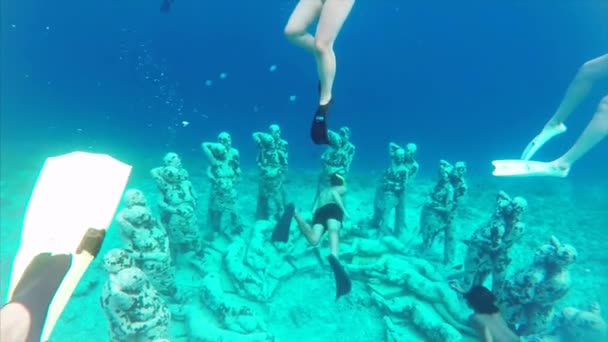 在印度尼西亚 游客们在洋底用清澈的蓝色巴厘海水覆盖着海草 在水下俯冲和探索男女雕像 — 图库视频影像