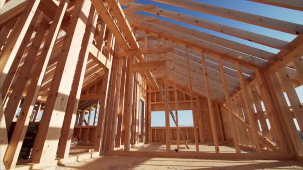 Unfinished frame house interior with wooden beams of roof and walls with blue sky on background — Stock Footage Unfinished Frame House Interior Wooden Beams Roof Walls Blue Sky Video Clip