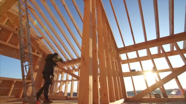 Budowniczowie Pracujący Niedokończonym Wnętrzu Domu Szkieletowego Drewnianymi Belkami Dachu Ścianami — Wideo stockowe
