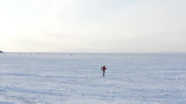 Kışın donmuş Amur koyunda koşan sporcunun hava manzarası, Vladivostok, Rusya