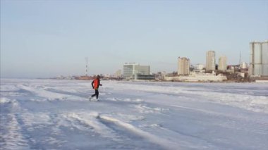 Kışın donmuş Amur koyunda koşan sporcunun panoramik hava manzarası, Rusya Vladivostok