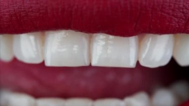 Kadın ağzı ve dili yakından görmek seksi kırmızı rujla dudakları yalamak ve mükemmel beyaz dişleri göstermek.