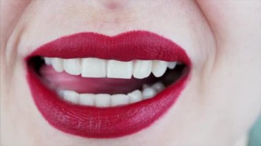 Kadın ağzı ve dili yakından görmek seksi kırmızı rujla dudakları yalamak ve mükemmel beyaz dişleri göstermek.