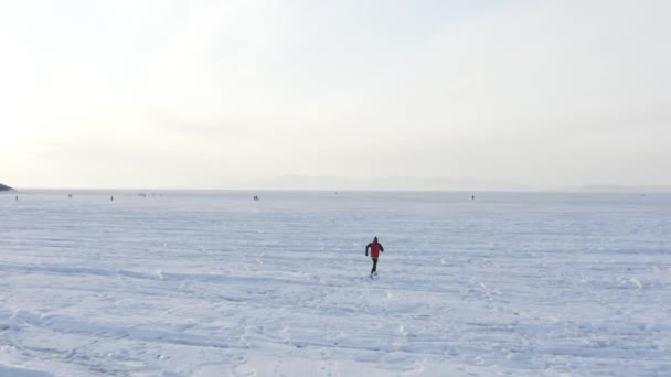 俄罗斯符拉迪沃斯托克冬季在冰冻的阿穆尔湾冰上跑步运动员的航拍照片 — 图库视频影像