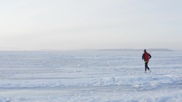 Aerial view of sportsman running on ice of frozen Amur bay in winter, Vladivostok, Russia — Stock Footage Aerial View Sportsman Running Ice Frozen Amur Bay Winter Vladivostok Stock Video
