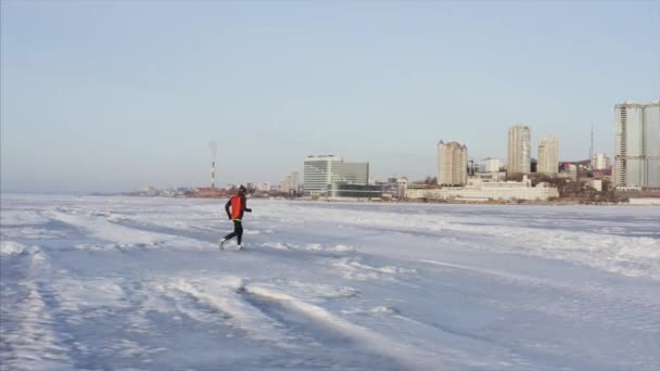 俄罗斯符拉迪沃斯托克冬季在冰冻的阿穆尔湾冰上跑步运动员的全景航空图 — 图库视频影像