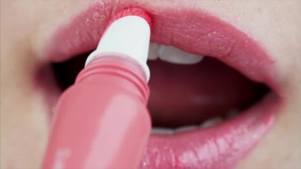 Vrouw Toepassen Roze Glans Lippen Blazen Kus Close View — Stockvideo