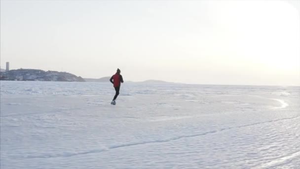 冬に凍結アムール湾の氷の上で実行されているスポーツマンのパノラマ航空ビュー ウラジオストク ロシア — ストック動画
