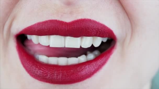 女性嘴和舌头用性感的红色口红舔嘴唇 露出完美的白牙的近景 — 图库视频影像