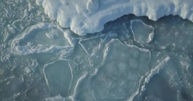 Deniz yüzeyinde deniz dalgalarıyla hareket eden karlı buz kütleleri. Kış konsepti