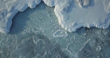 Deniz yüzeyinde deniz dalgalarıyla hareket eden karlı buz kütleleri. Kış konsepti