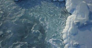 Deniz yüzeyinde deniz dalgalarıyla hareket eden karlı buz kütleleri. Kış konsepti