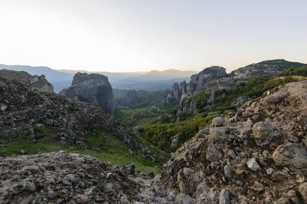Meteors with Orthodox Monasteries,  view from the plateau to the valley of a cliff top and of Thessaly.  Stunning  landscape at sunset. View at mountains and green forest against epic sky with clouds. UNESCO heritage list object.