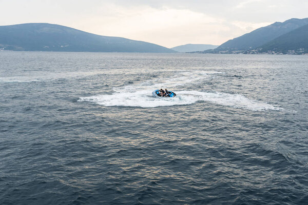 a guy and a girl riding a hydrocycle in the sea near the shore. Pleasure. happy, excited couple 