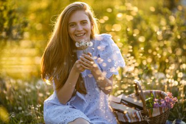 Parkta karahindiba taşıyan mutlu bir kadın