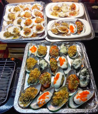 Grillled midye peynir ve metal tepsi üzerinde otlar ile