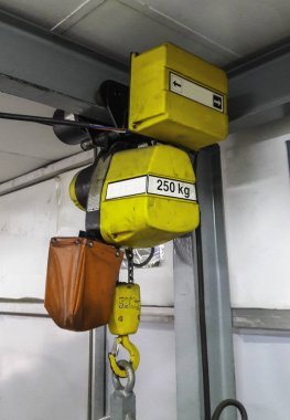 Electric hoist hanged on crain clipart