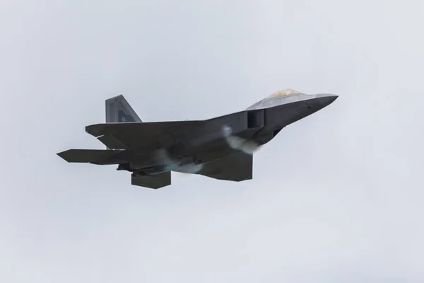 Быстрый пролет F-22A Raptor в сыром небе — стоковое фото