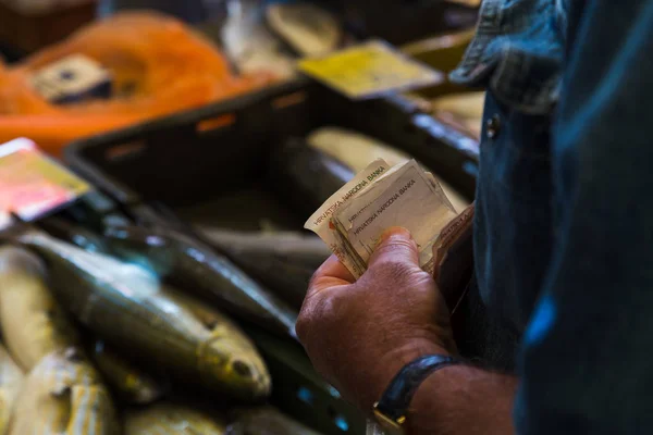 Деньги переходят из рук в руки на рыбном рынке Сплита — стоковое фото