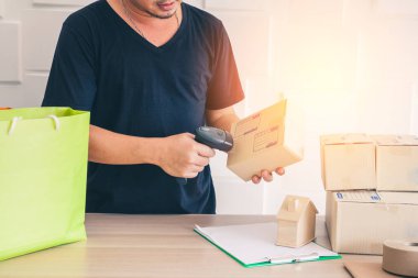 Mobil giyinen erkekler, tablet. Tezgahta dizüstü bilgisayarlar, nişancılar, barkodlar, ev modelleri, saksılar var..