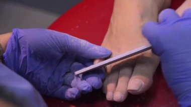 Manikürcüdeki yakın çekim makro kadın bir güzellik uzmanından manikür alıyor. Kadın manikür yaptırıyor. Güzellik uzmanı dosyasının bir müşteriye çivileri.