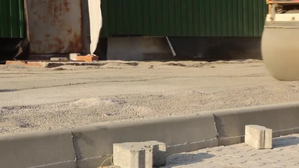 建設現場では大きな黄色いスケートリンクが舗装スラブの下の砂を踏みつけ — ストック動画