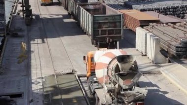 Beton karıştırıcı döner ve betonu boşaltmak için inşaat alanına gider. İnşaat alanında dört eksenli beyaz-turuncu beton karıştırıcı sürüşü