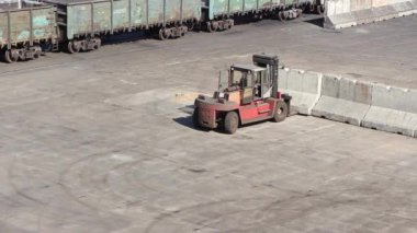 İskele tarafında yükleyici çalışması, kargo sınırlarını oluşturmak için beton blokları hareket ettiriyor.
