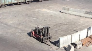 İskele tarafında yükleyici çalışması, kargo sınırlarını oluşturmak için beton blokları hareket ettiriyor.